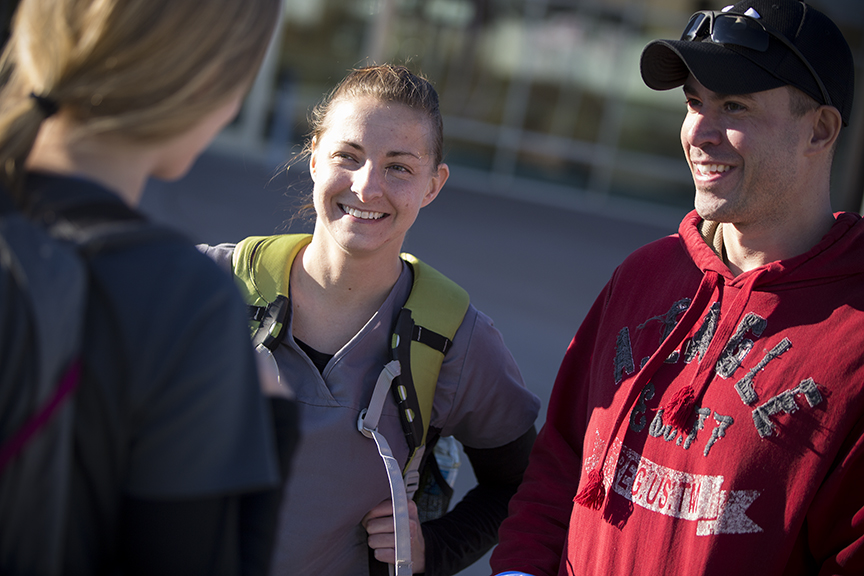 Image of three students chatting outside.