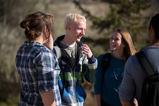 Image of four students talking on campus.